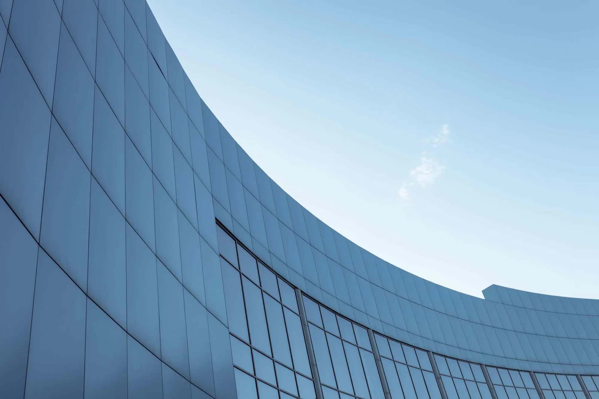Curved facade of a modern office building against a clear sky